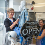 Two women smiling in a shop window